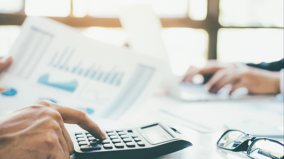 Person working on paperwork and using a calculator