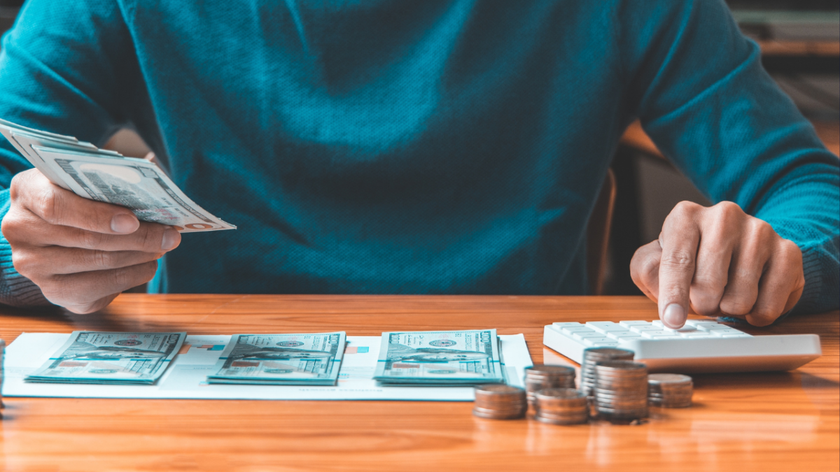 Man counting his money on a table