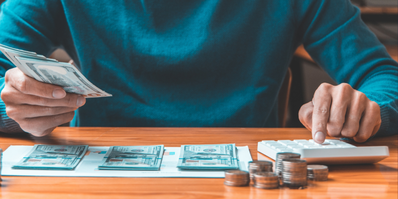 Man counting his money on a table