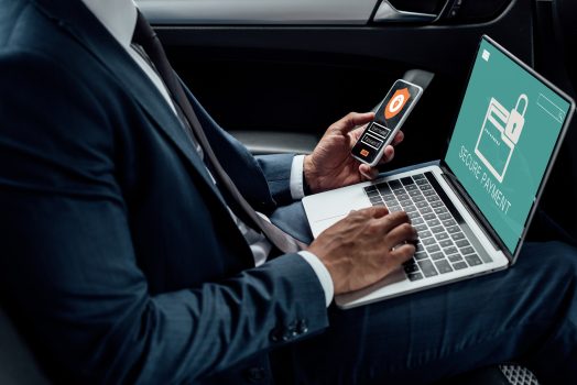 cropped-view-of-african-american-businessman-using-laptop-and-smartphone-in-car-with-cyber-security.jpg